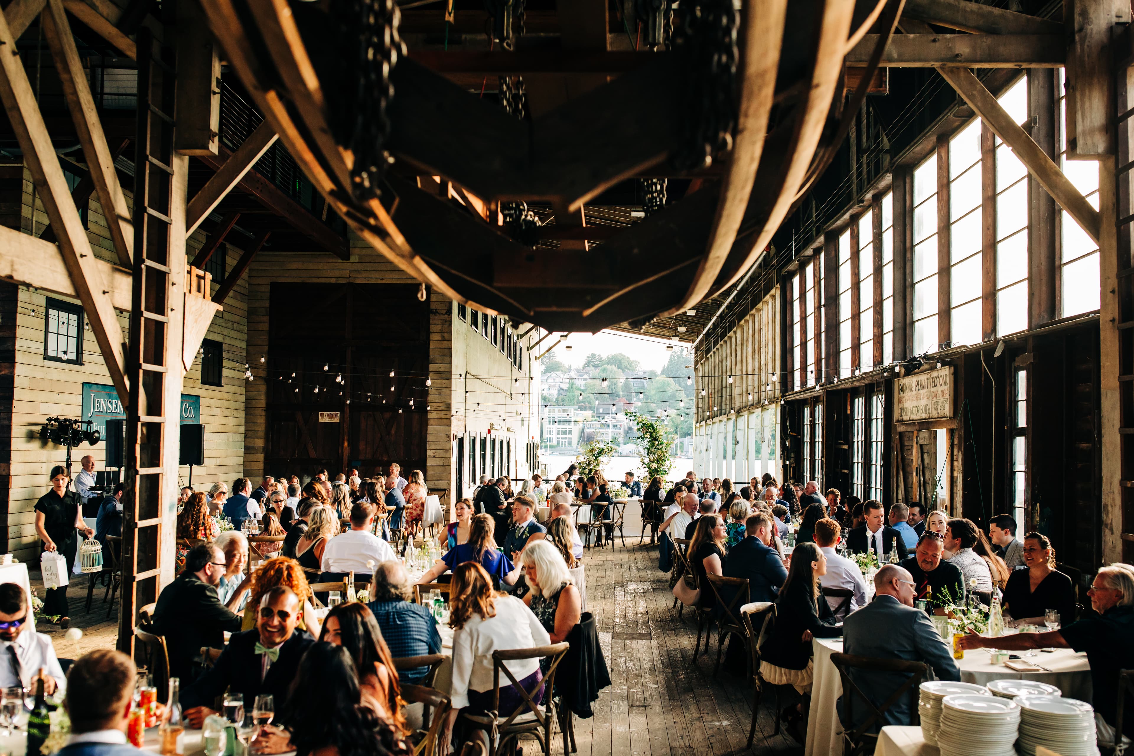 Elevated view of a wedding reception filling the barn alongside Portage Bay